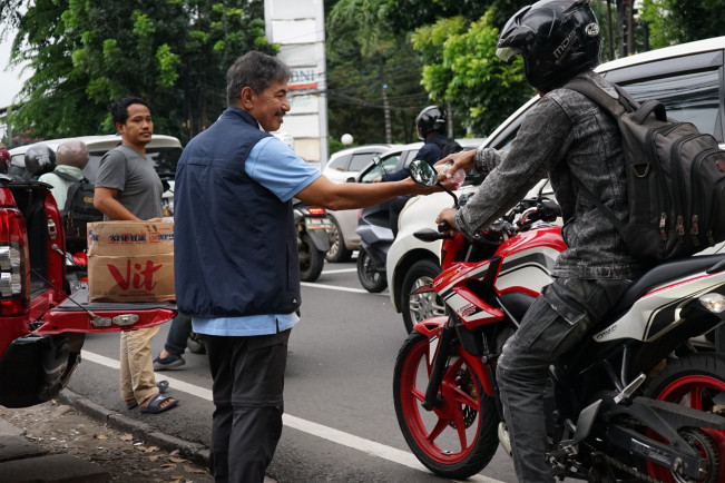 Pengurus GEMPITA membagikan takjil kepada pengendara sepeda motor di pinggir jalan Jakarta Selatan menjelang buka puasa