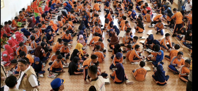 Ratusan siswa SDN 143 Rejang Lebong duduk berjajar di aula sekolah menyantap makan bergizi pada hari pertama uji coba program GEMPITA